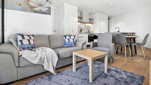 Un salon moderne comprenant un canapé, une table basse et un coin repas avec des chaises et une table.