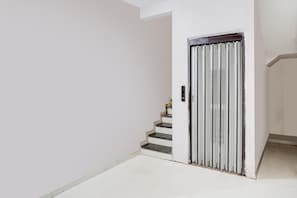 Escada que leva a uma porta com puxador vertical.