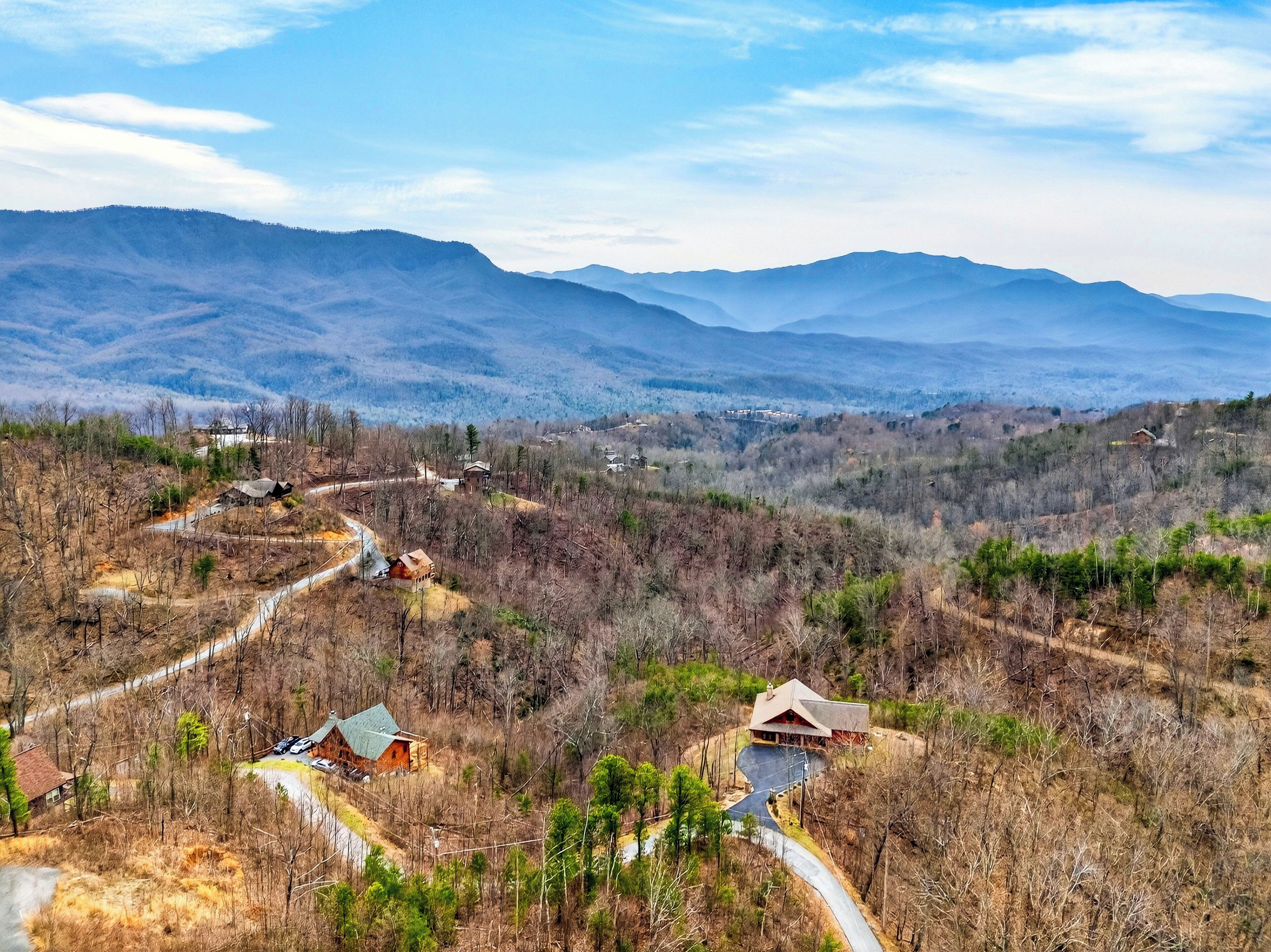 A mountainous landscape with several cabins and a winding road.