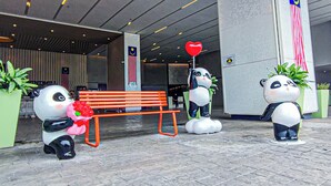 Een panda-beeldhouwwerk vasthoudend een rood hart, een bank en een vlag.