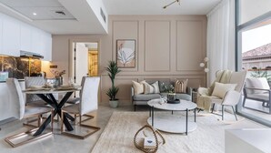 Un salon moderne comprenant un coin repas, un ensemble de canapés, une table basse et une grande fenêtre.