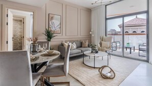 Un salon moderne comprenant un coin repas, un canapé, une table basse et offrant une vue sur la ville grâce à de grandes fenêtres.
