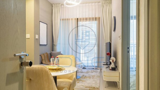 Une chambre d’hôtel moderne dotée d’un coin repas, d’un canapé, d’une télévision et offrant une vue sur la ville.