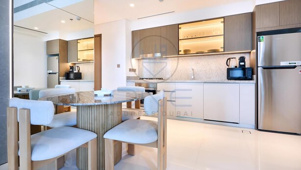 Une cuisine moderne dotée d’un îlot central, d’appareils électroménagers intégrés et d’un coin repas avec une table ronde et des chaises.