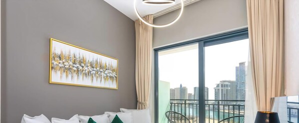 A modern room with a city view, a framed artwork on the wall, and a balcony with a chair. - 1BR Zada Tower l Two Balconies & City Views (Dubai)
