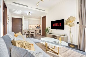 Ein modernes Wohnzimmer mit einer Couch, einem Couchtisch und einem Flachbildfernseher, der 'NETFLIX' anzeigt.