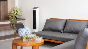 A modern living room with a sofa, a coffee table, and a TV. - Perenenan Home (Pererenan)