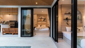 A modern interior with a bed, bedside tables, and a view through a glass door. - Perenenan Home (Pererenan)