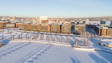 Un complesso residenziale di grattacieli con diversi condomini, un parcheggio e un paesaggio innevato.
