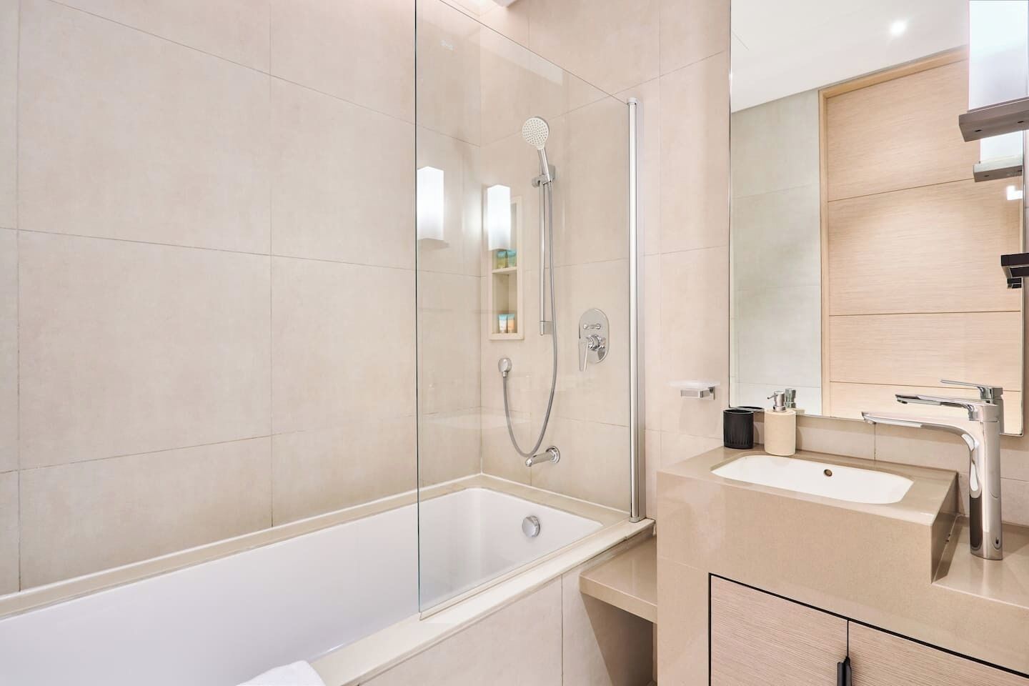 Een moderne badkamer met een douchecabine, een bad en een wastafelmeubel met wastafel en spiegel.