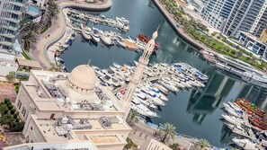 Un puerto deportivo con numerosas embarcaciones amarradas, una cúpula destacada y edificios modernos al fondo.