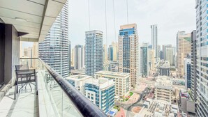 A high-rise building with a glass balcony overlooking a cityscape. - Marina View, Fully Furnished, Close to Marina Walk (Dubai)
