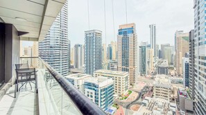 A high-rise building with a glass balcony overlooking a cityscape. - Marina View, Fully Furnished, Close to Marina Walk (Dubai)