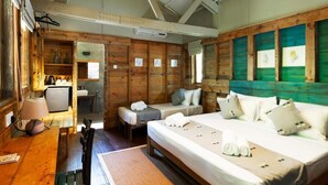 A wooden cabin with two beds, a small kitchenette, and a dining area. - Varanya By Regus (Habarana)