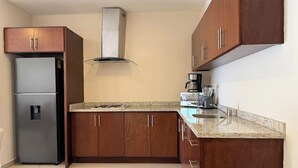 Cafetera o tetera, frigorífico, microondas y placa de cocina