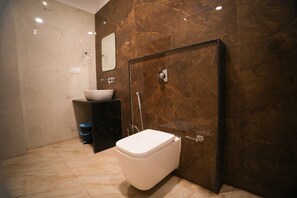 A modern bathroom with a toilet, sink, and shower. - Hotel Maruti Nandan (Varanasi)