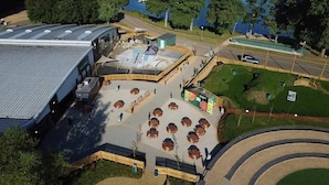 An aerial view of a commercial building with a parking lot, a central plaza with seating, and a small green area. - Elegant 2 Bed One and Half Bath Caravan in Holiday Resort - Sleeps 6 (Great Billing)