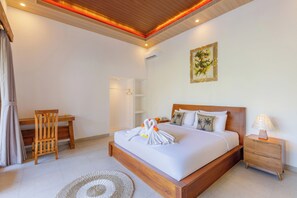 Ein Schlafzimmer mit einem hölzernen Bett, einem Schreibtisch, einem Stuhl, einem Nachttisch und einer Wand-Klimaanlage.