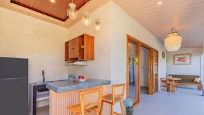 Eine moderne Küche mit Marmorarbeitsplatte, Holzschränken und einem Essbereich mit Tisch und Stühlen.