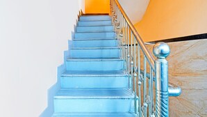 A staircase with blue steps and a metal railing. - Hotel O Mana Camp Near Airport (Raipur)