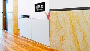 A reception desk with a sign that reads 'HOTEL' and a logo indicating it is company-serviced. - Hotel O Mana Camp Near Airport (Raipur)