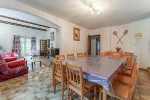 Un comedor con una mesa grande, sillas de madera y un sofá.