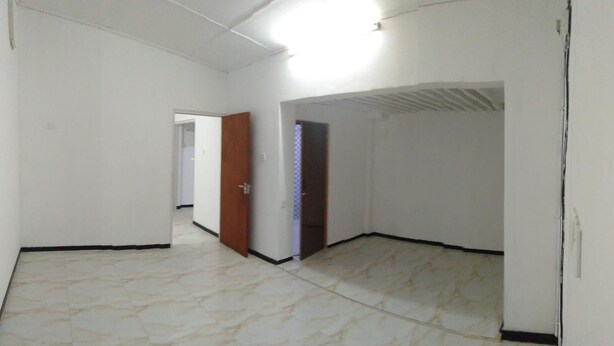 A room with white walls, a tiled floor, and a door leading to another room. - Nice home in Nice Neighbourhood (Colombo)