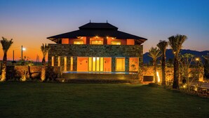 A two-story house with a stone facade, large windows, and a flat roof. - ELIVAAS The Kanota Retreat 4 BHK Villa (Jaipur)