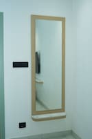 A bathroom with a large mirror, a towel rack, and a toilet.