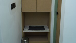 Un couloir étroit avec un petit espace de rangement et une poubelle.