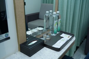A tray with bottles, glasses, and a tissue box on a marble countertop.