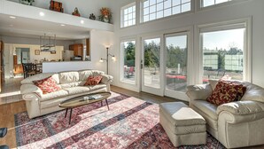 A spacious living area with a large window, a sofa, a coffee table, and a rug. - Sweetmoss Is Lovely! 3 Mi to Acadia Nat'l Park (Mount Desert)