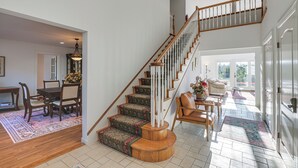 A spacious living area with a wooden staircase, a dining set, and a view to the outdoors. - Sweetmoss Is Lovely! 3 Mi to Acadia Nat'l Park (Mount Desert)