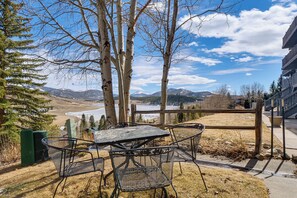 A patio with metal chairs and a table, overlooking a river and mountains. - Steps to Lake Dillon & Main St! All-Season Escape (Dillon)