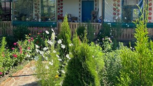A wooden house with a porch, large windows, and a blue door. - Cozy nature escape for relaxation, connection, and memorable stays (Poiana cu Cetate)