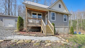 A two-story house with a front porch, a staircase, and a garage. - 2BD Mtn Retreat near Nantahala w/ Firepit and Pond (Andrews)
