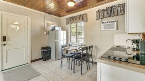 A kitchen with a wooden ceiling, white walls, a refrigerator, a sink, and a dining table with chairs. - Lake Days + Pool Fun! Nature Coast Retreat (Hernando)