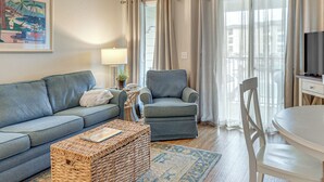 Ein Wohnzimmer mit Sofa, Sesseln, Couchtisch und Fernseher.
