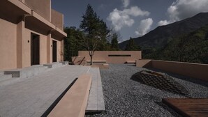 A modern building with a flat roof, outdoor seating area, and a view of mountains. - spiderHoteOne (Hangzhou)
