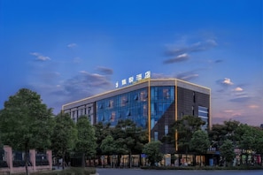 Un moderno edificio de hotel con fachada de vidrio y señalización que indica que es un hotel.