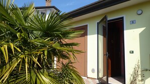 Un bâtiment avec une porte marron, une plaque portant le numéro « 9 » et une cheminée.