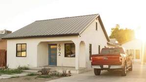 A single-story building with a metal roof, a blue door, and the number 692 on the front.