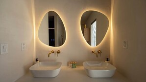 A bathroom with two sinks, each with a large mirror above.