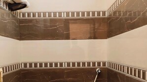 Ein kleines, modernes Badezimmer mit Toilette, Dusche und Handtuchhalter.