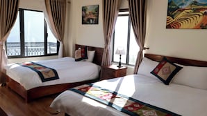 A hotel room with two beds, a nightstand, a lamp, and a balcony with a view. - An Hotel (Sa Pa)