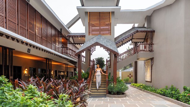 A hotel with a covered staircase, a central atrium, and a well-maintained garden area. - Sstella Empire Beach Resort, a member of Radisson Individuals (Calangute)