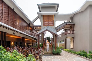 A hotel with a covered staircase, a central atrium, and a well-maintained garden area. - Sstella Empire Beach Resort, a member of Radisson Individuals (Calangute)