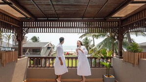 A covered balcony with a wooden railing, a potted plant, and a view of the ocean. - Sstella Empire Beach Resort, a member of Radisson Individuals (Calangute)