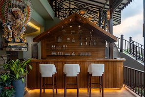 A bar area with wooden bar counter, three white barstools, and a decorative ceiling. - Sstella Empire Beach Resort, a member of Radisson Individuals (Calangute)