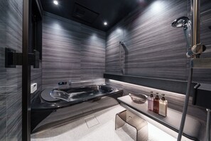 Suite | Badkamer | Een bad/douchecombinatie, een diep bad, een haardroger, pantoffels